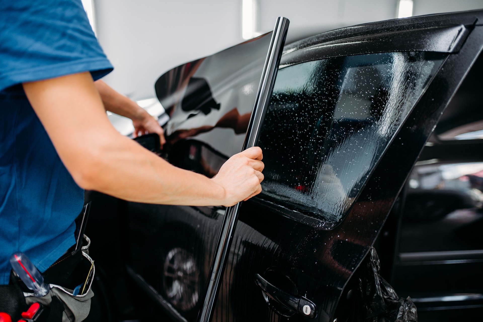 Male specialist applying car tinting film